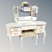 A cream and gilt kidney shaped dressing table with triple mirror and stool