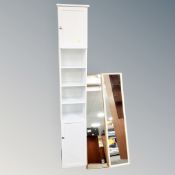 A narrow white bathroom double door cabinet with shelves,