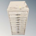 A metal ten drawer filing chest containing hand tools and hard ware