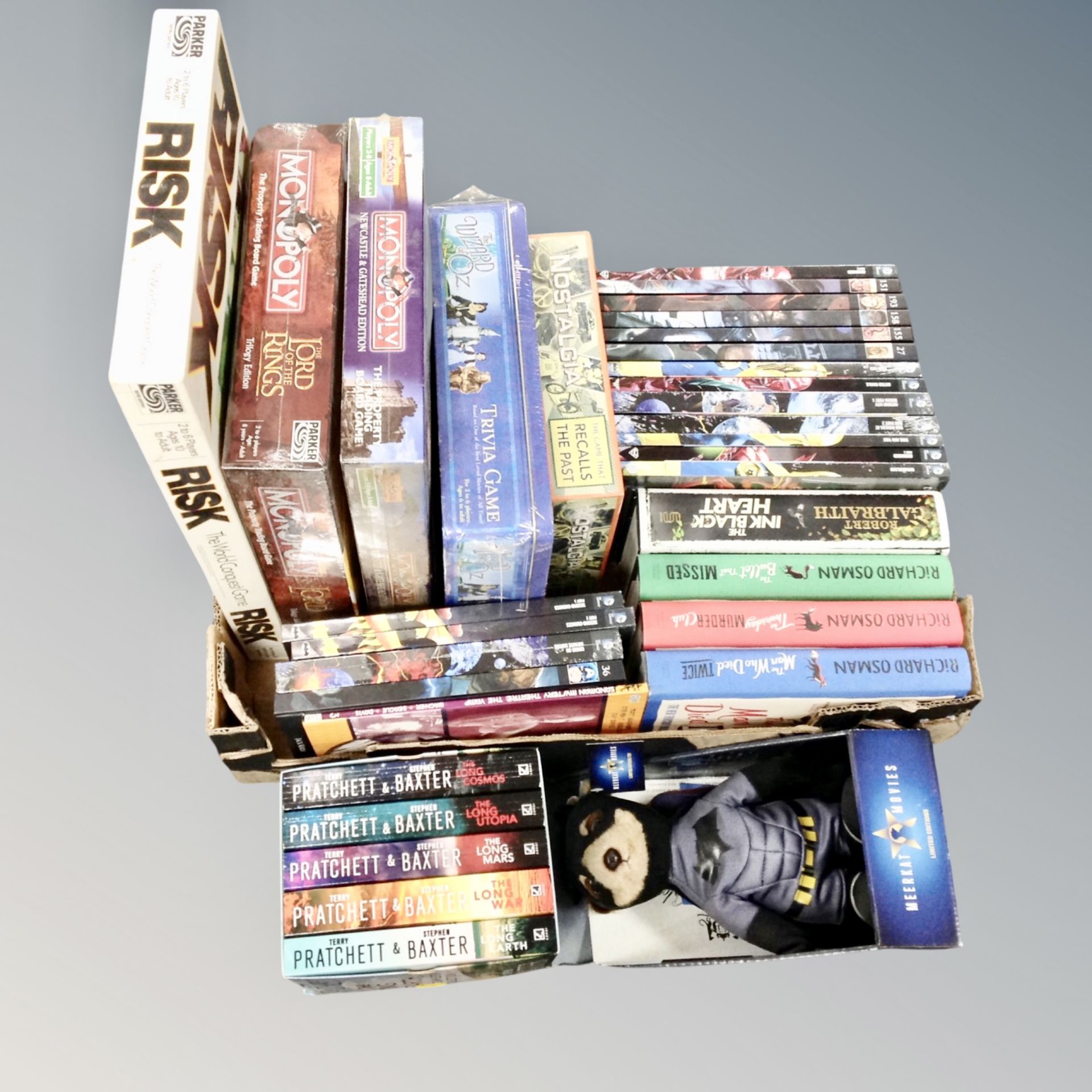 A box of board games to include sealed Trivia game, Monopoly, Terry Pratchett box set,