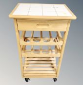 A contemporary pine kitchen wine rack trolley with tiled top