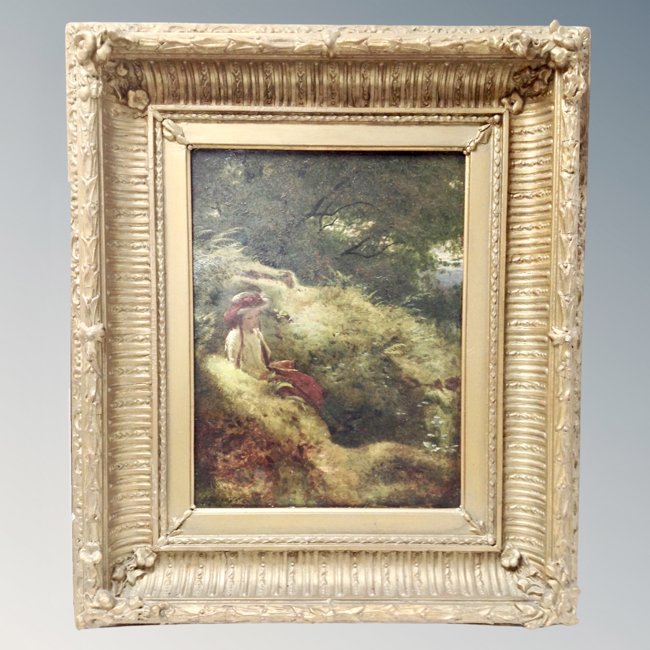 19th century school, Female figure seated in grassland, oil on board, in gesso frame.