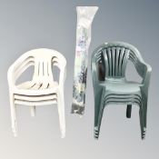 A set of four plastic stacking garden chairs together with a set of three stacking plastic chairs,