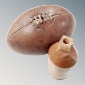 A vintage leather rugby ball and a stoneware bottle