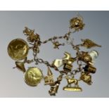 A 9ct gold charm bracelet set with many charms and two silver-gilt coins, 69.6g.