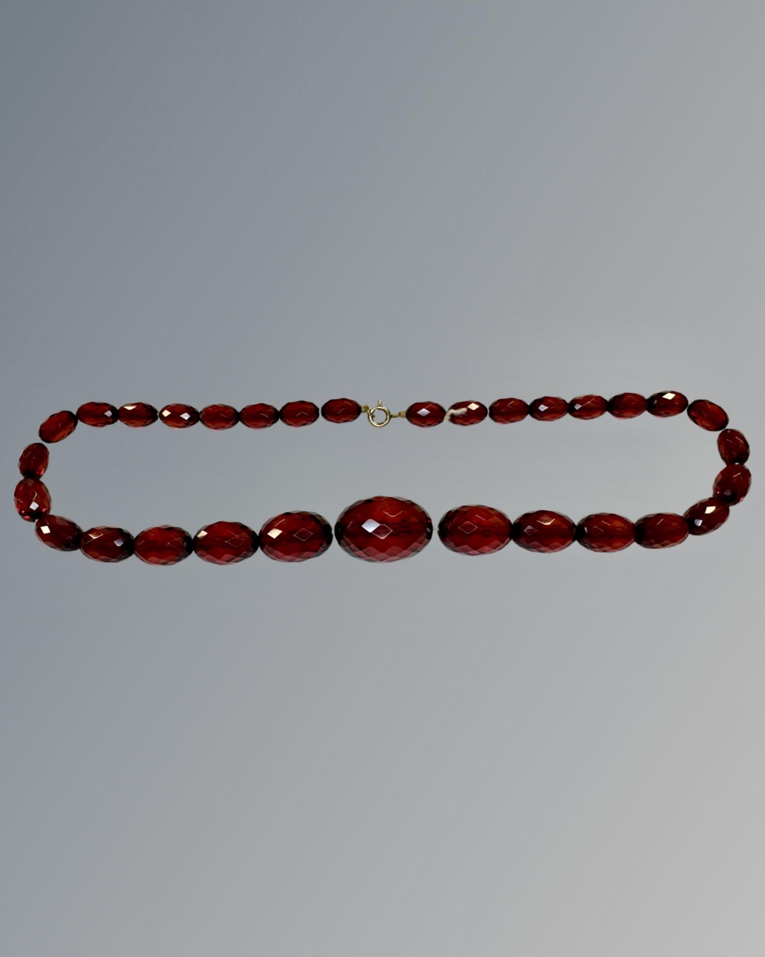 An amber beaded necklace with yellow gold clasp.