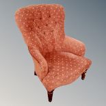A Victorian style buttoned lady's armchair in red fabric