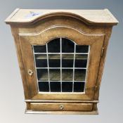 A 20th century oak leaded glass door wall cabinet fitted a drawer