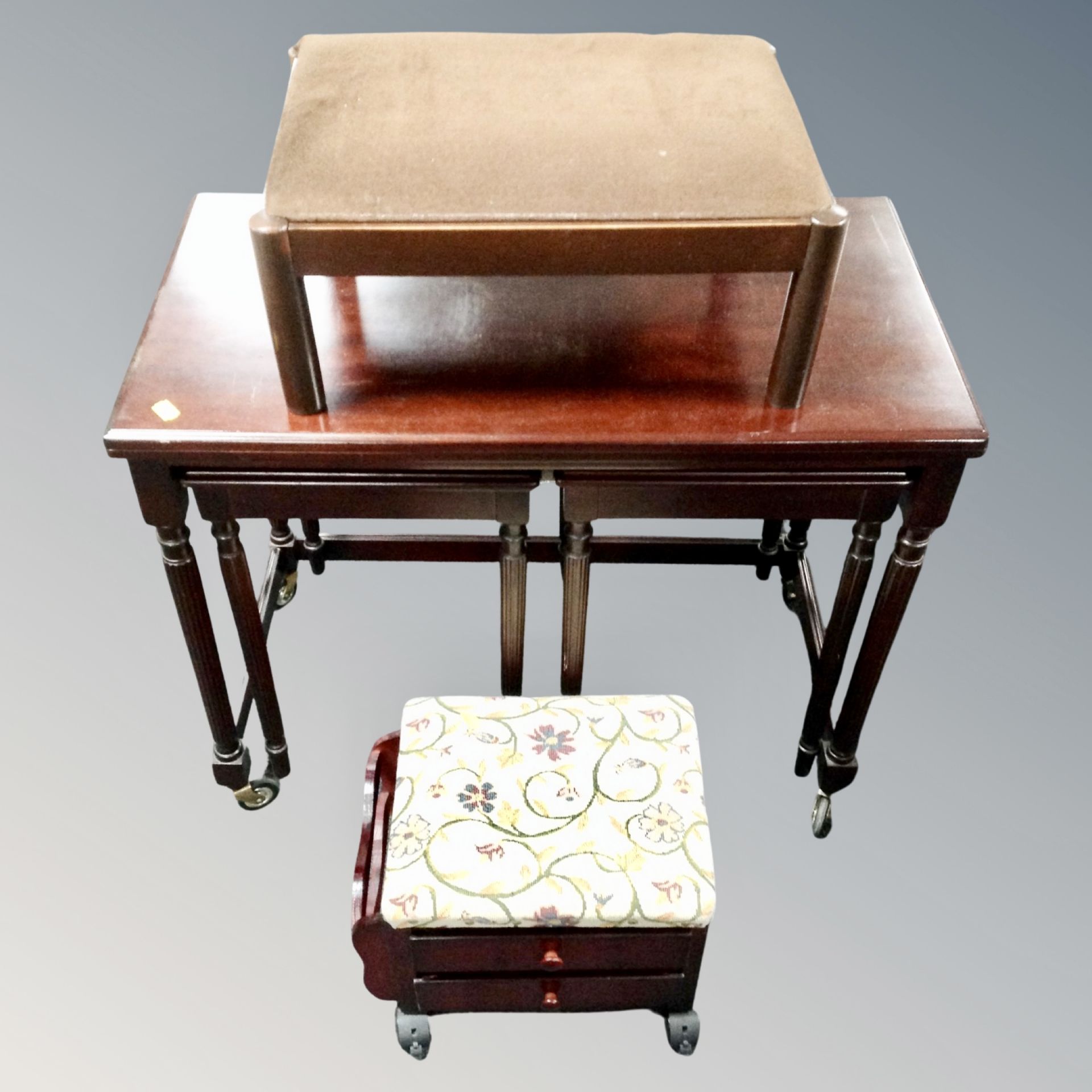A nest of three mahogany tables with turnover top together with upholstered footstool and further