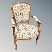 A carved beech framed armchair in tapestry covering