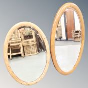 An antique oval pine framed mirror and a further oval mirror