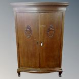 An early 20th century oak double door cabinet on raised legs