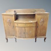 An early twentieth century Scandinavian oak break fronted four door sideboard