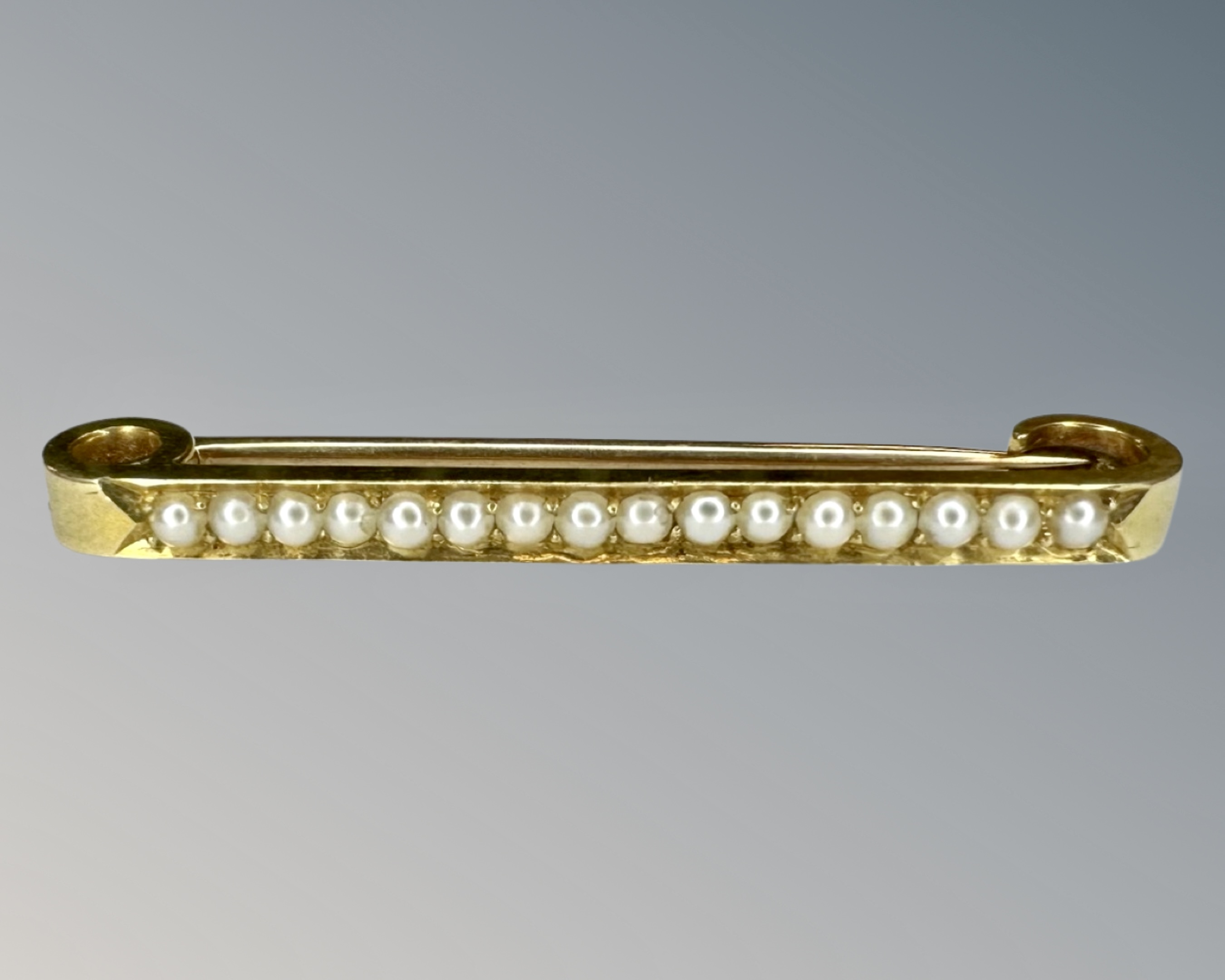 A 15ct gold pearl set bar brooch, width 4.5 cm.