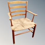 A mid century ladder backed armchair with rush seat