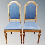 A set of seven high backed oak dining chairs in blue fabric