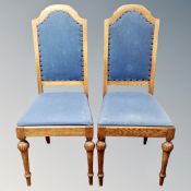 A set of seven high backed oak dining chairs in blue fabric