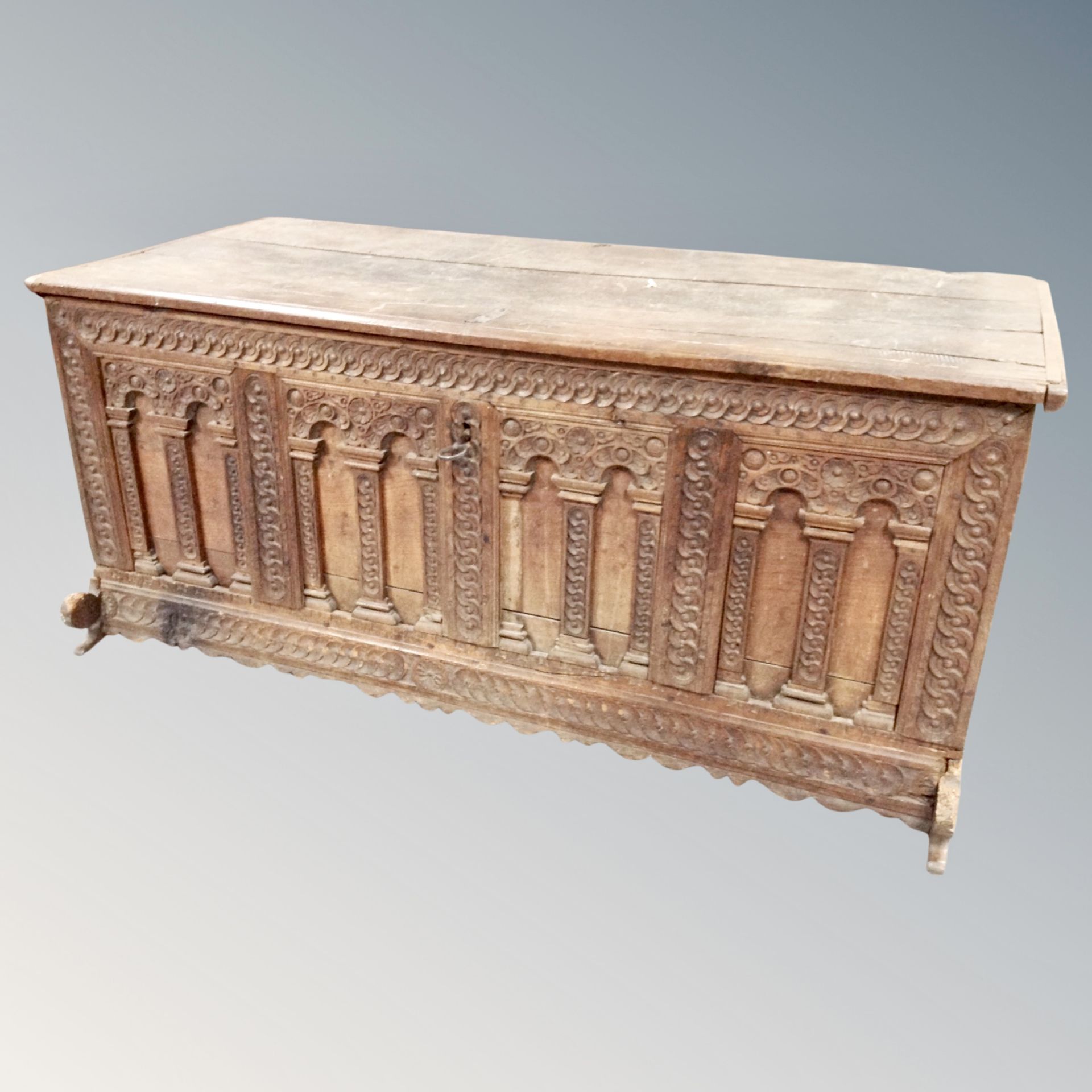 An early 19th century heavily carved oak coffer height 74 cm, width 171 cm, depth 77 cm.