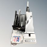 An Oreck upright vacuum cleaner together with an XL hand held vacuum with accessories