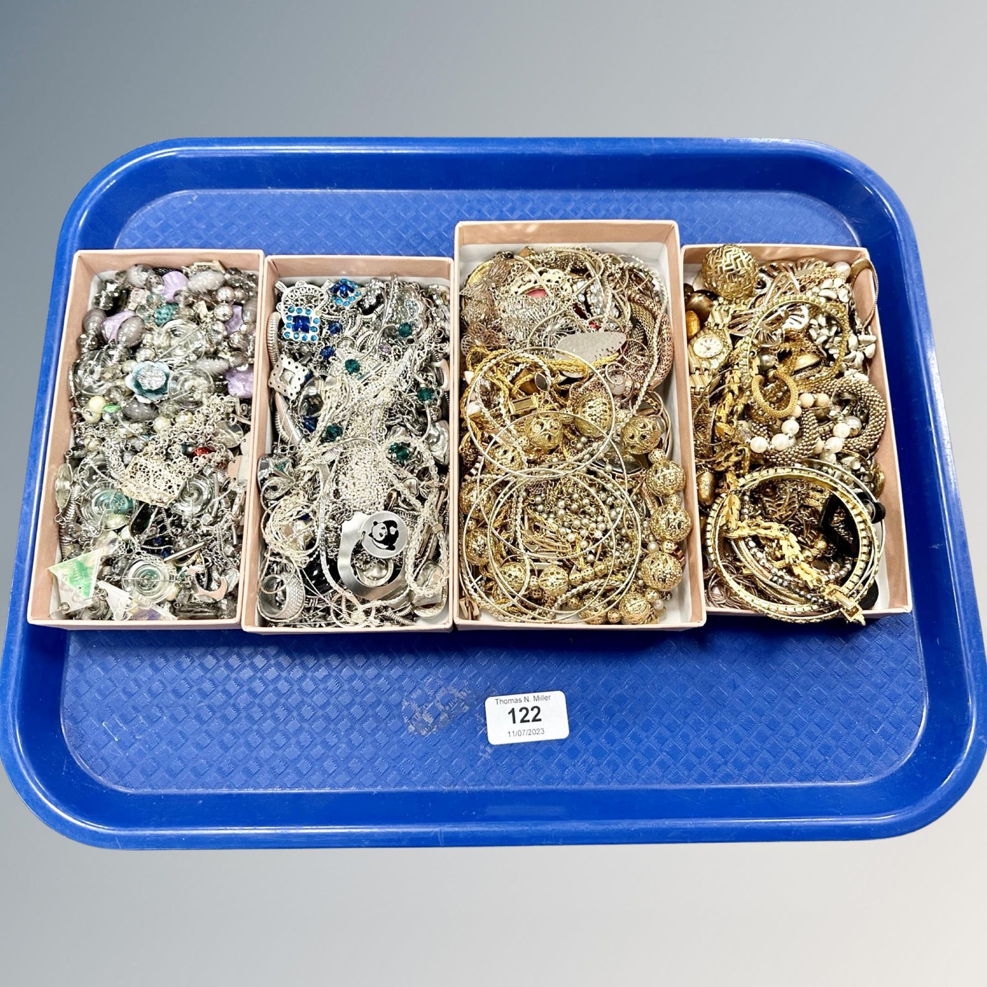 A tray of silver tone and gold tone costume jewellery