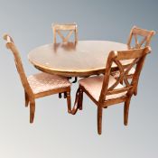 A contemporary circular pedestal dining table with leaf together with four matching chairs