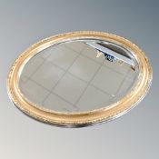 A contemporary gilt and silver oval framed mirror