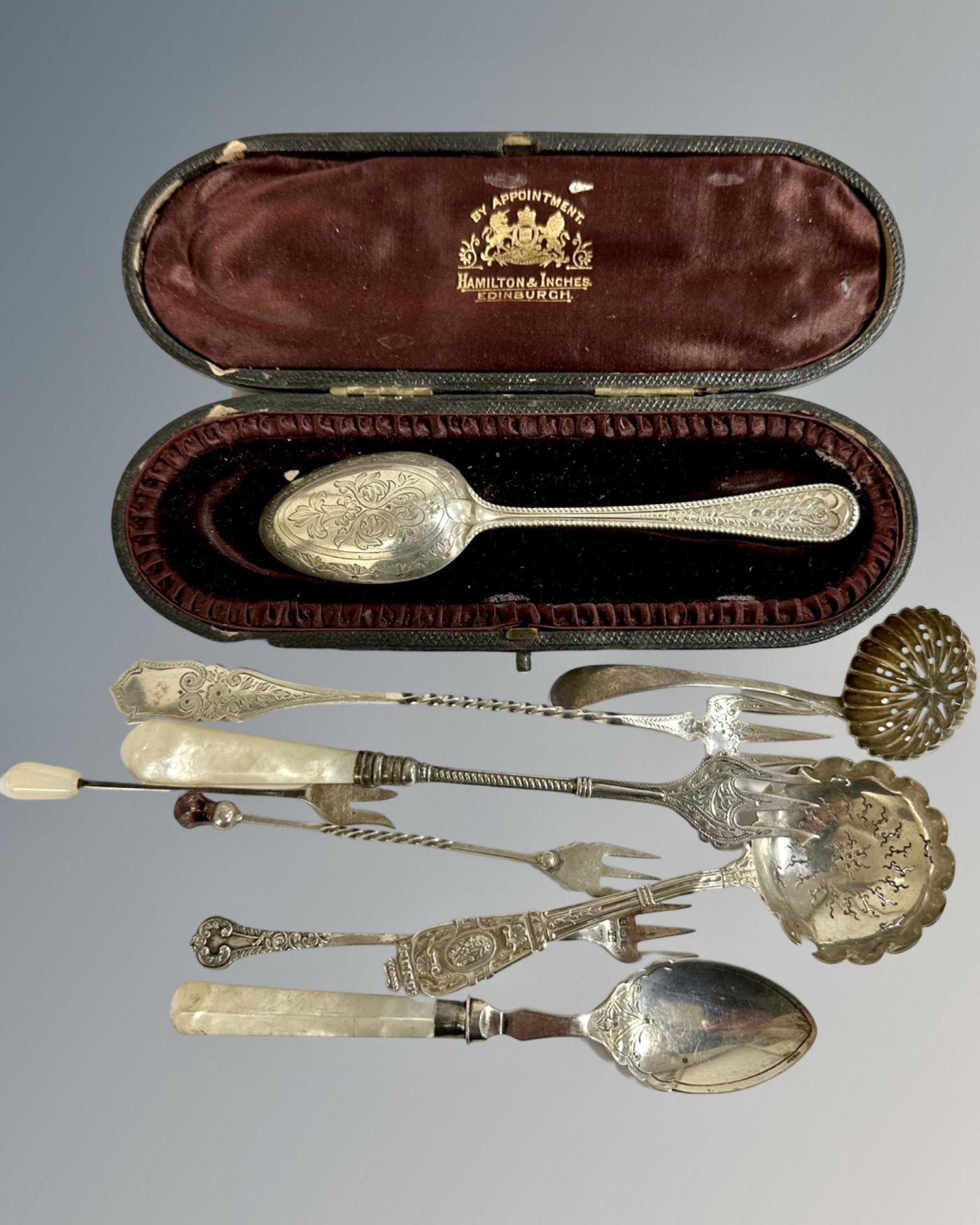 A collection of silver cutlery, pickle forks, cased spoon etc.