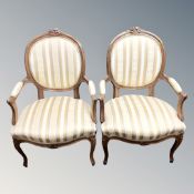 A pair of French carved walnut open salon armchairs in cream and gilt striped fabric