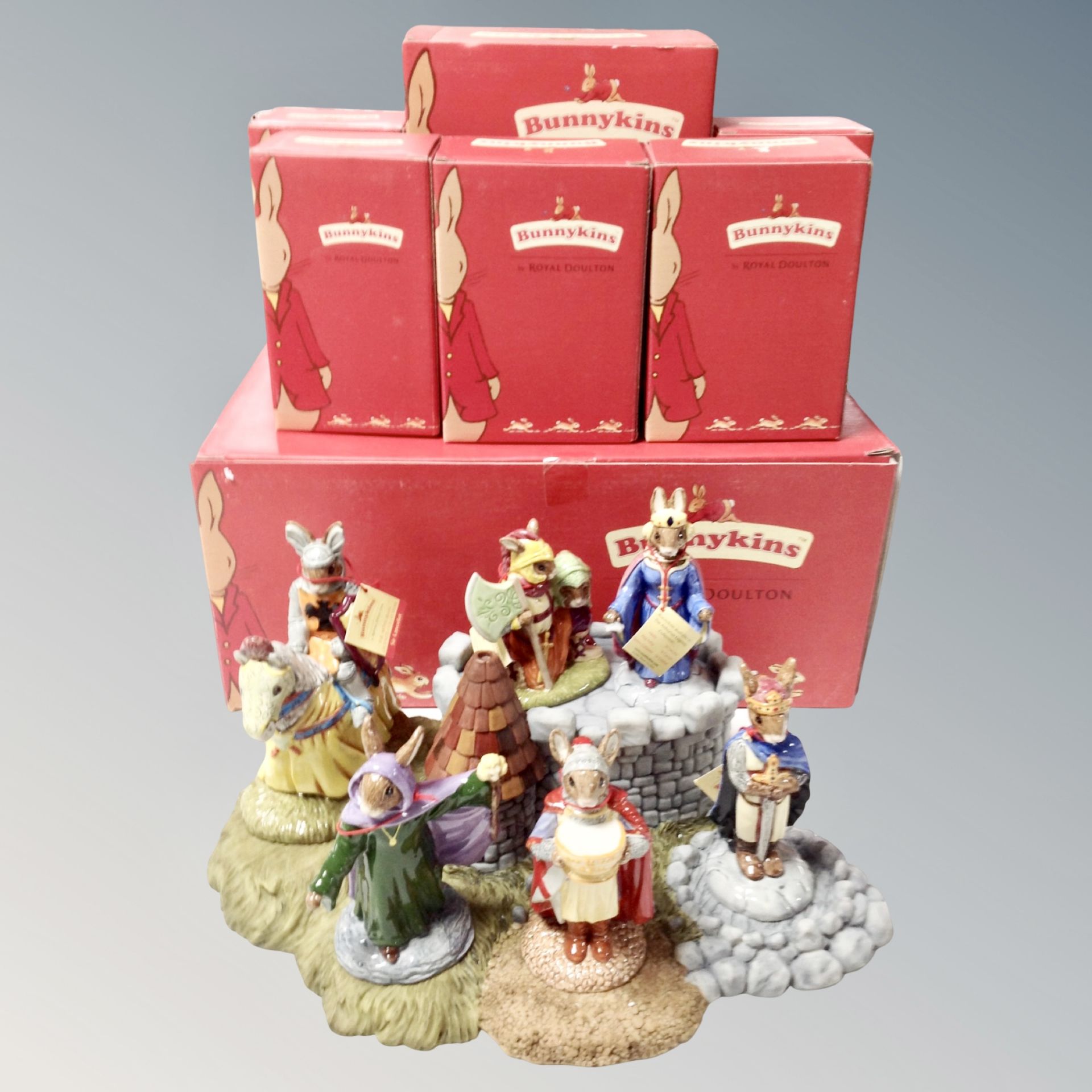 A Royal Doulton Bunnykins stand together with six figures,
