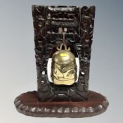 A brass temple bell on carved wooden stand, height 39 cm.