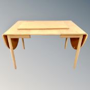 A Scandinavian square extending dining table with leaf in oak finish