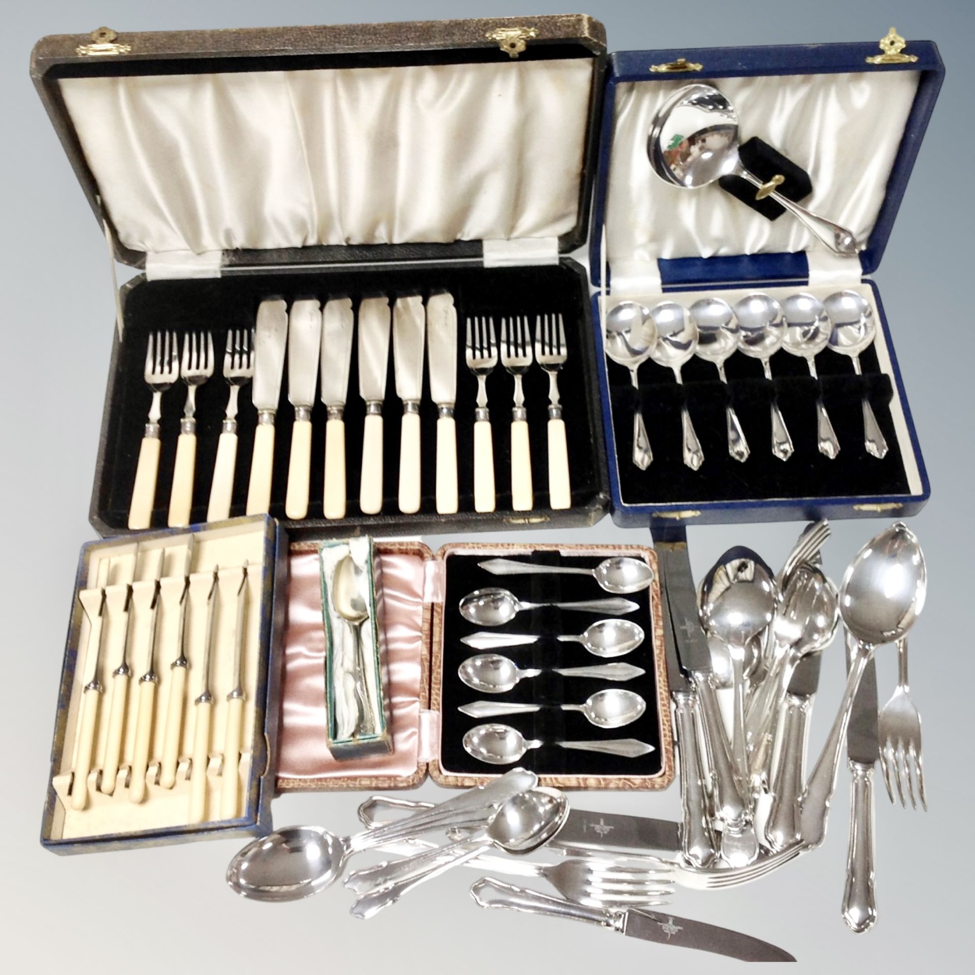 A tray of stainless steel and plated cutlery,