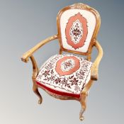 A carved beech framed armchair in tapestry covering