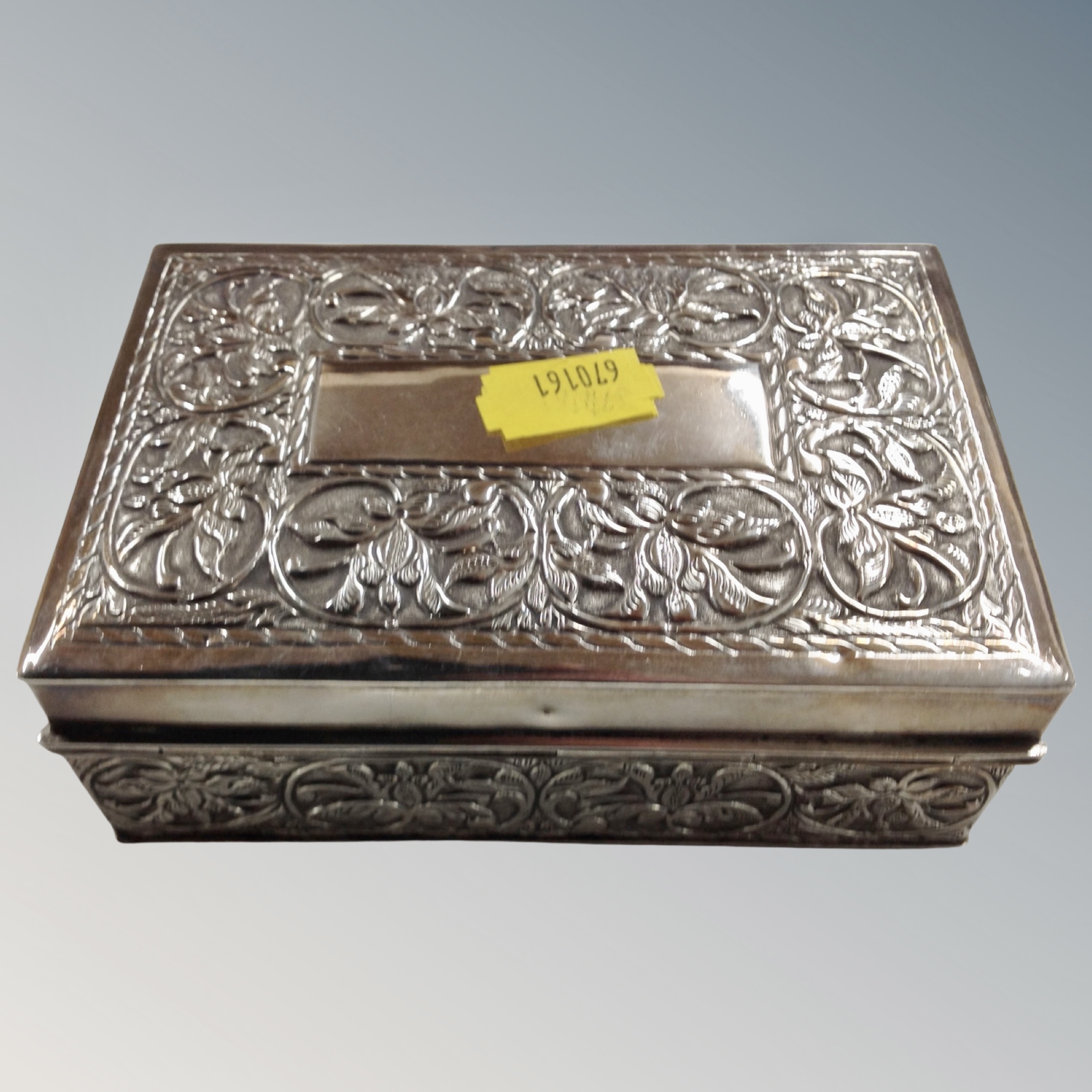 A middle Eastern embossed silver cigarette box