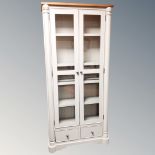 A contemporary double door glazed bookcase fitted with drawers beneath with oak top