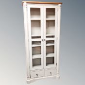 A contemporary double door glazed bookcase fitted with drawers beneath with oak top