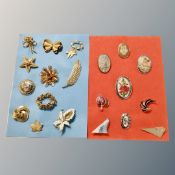 A collection of gilded metal tapestry and enamel brooches mounted on cloth