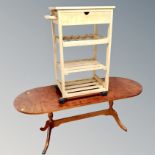 An oval inlaid yewwood twin pedestal coffee table together with a pine kitchen trolley
