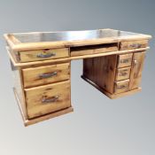 A plantation pine twin pedestal desk fitted with drawers,
