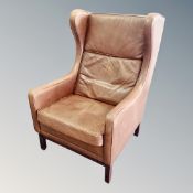 A 20th century Danish brown leather wing backed armchair