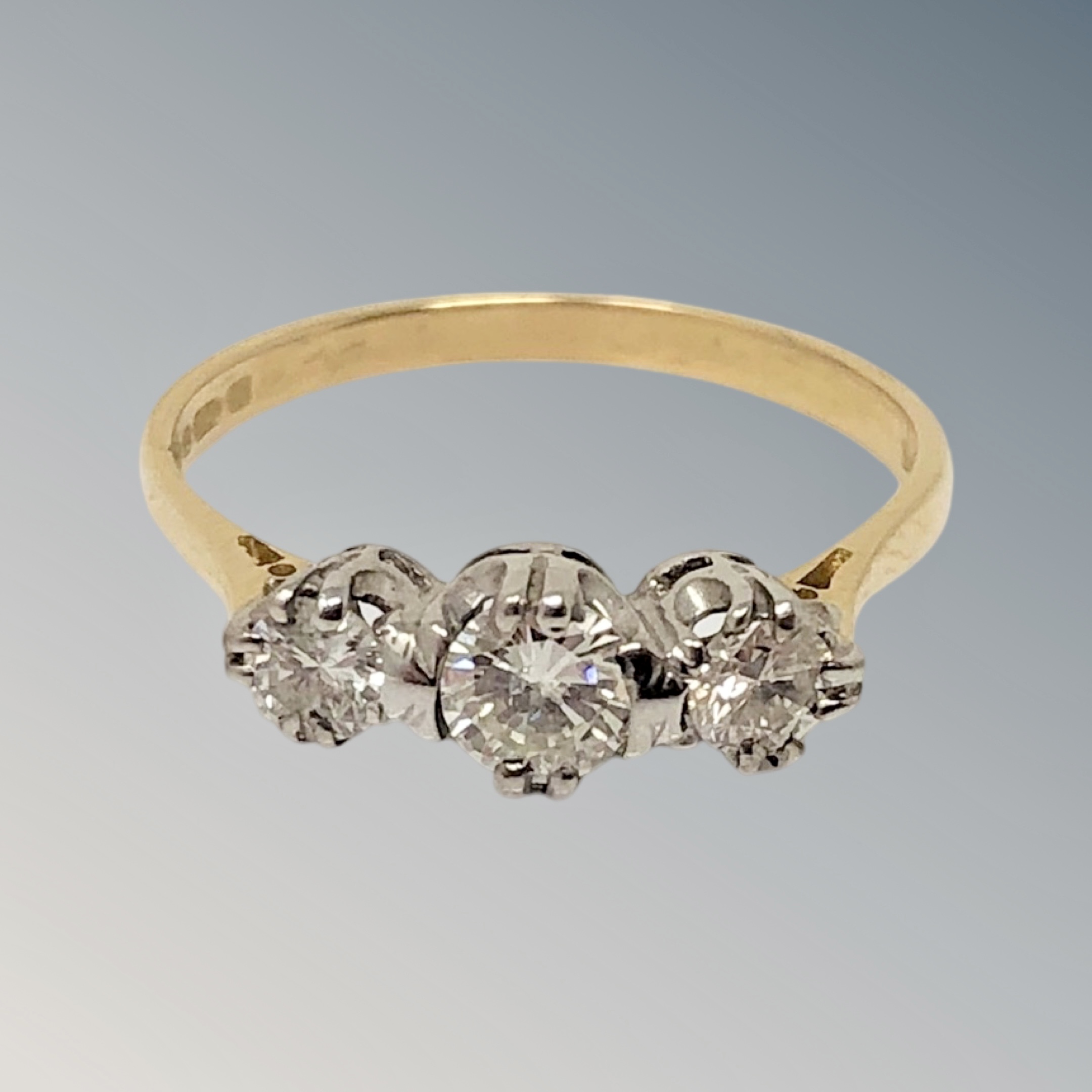 An 18ct gold three stone diamond ring, size N CONDITION REPORT: 2.