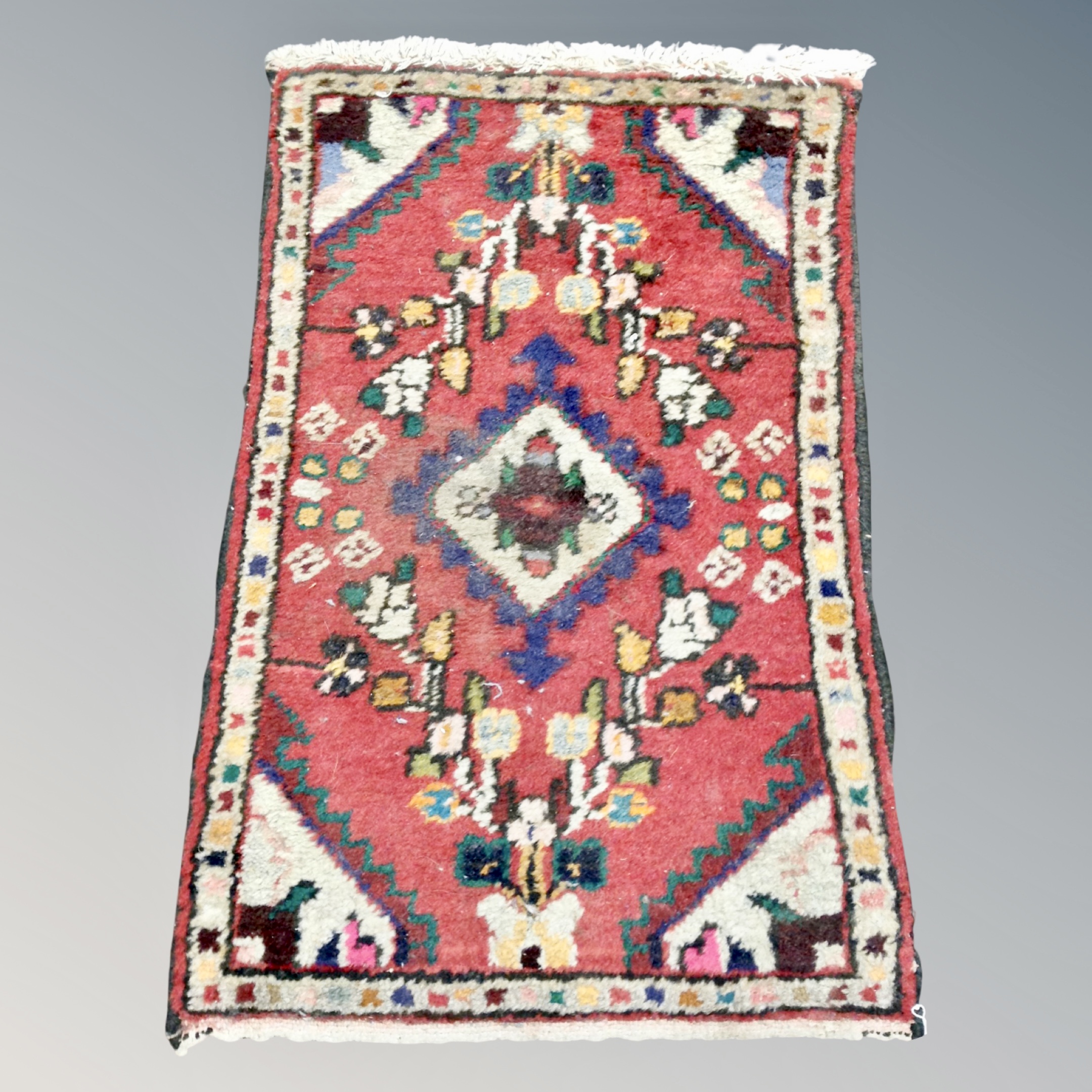 An Eastern hearth rug 64 cm x 43 cm