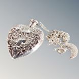 An antique silver perfume heart shaped bottle on white metal chain with charms