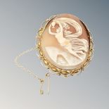 An ornate gold cameo brooch with gold safety chain