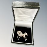 A silver horse brooch