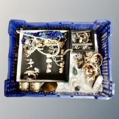 A basket of costume jewellery, beaded necklaces, earrings, dress rings, bracelets, gilt compact,