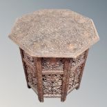 A teak octagonal heavily carved Indian occasional table