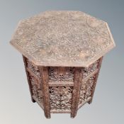 A teak octagonal heavily carved Indian occasional table
