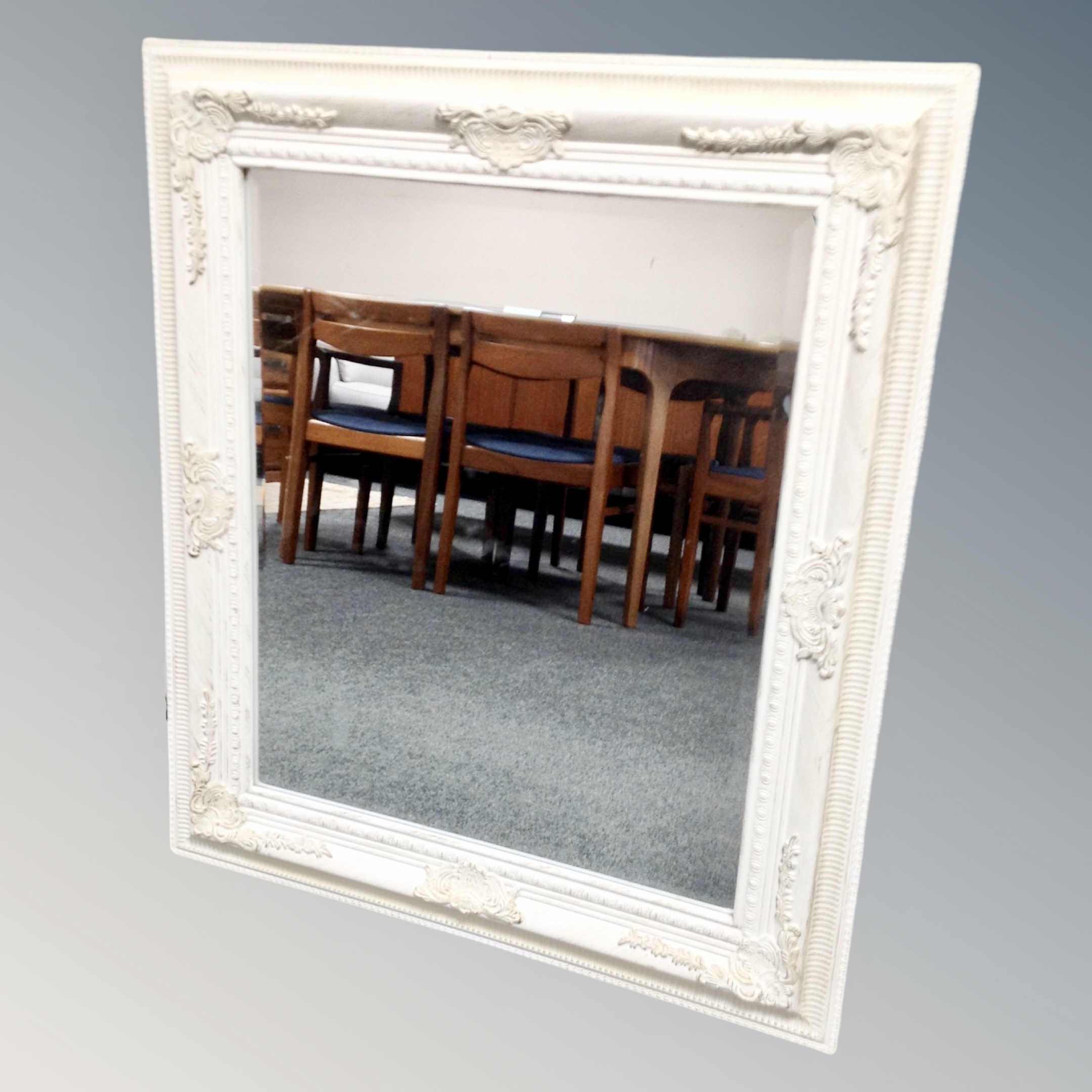 A classical framed white bevelled mirror