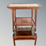 A mid century teak two tier trolley together with a further teak coffee table with smoked glass top